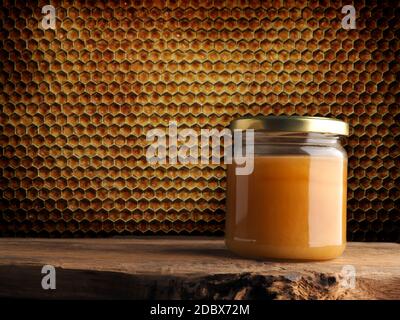 Un pot de miel sur une table rustique en bois sur un fond en nid d'abeille avec de l'espace pour le texte. Concept d'alimentation saine Banque D'Images