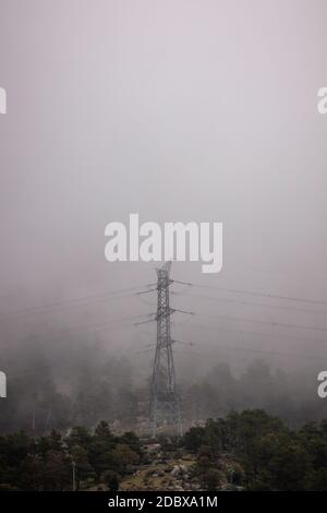 Tour d'alimentation électrique isolée sur la montagne. Infrastructure de distribution d'électricité. Arrière-plan brumeux, une tempête dangereuse est approche Banque D'Images