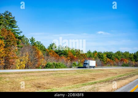 Puissant semi-camion diesel industriel gris avec réfrigérateur semi-remorque transportant des marchandises sur la route divisée avec des couleurs vives Banque D'Images