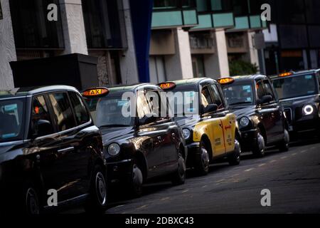 Une file de taxis noirs à l'extérieur de la gare Victoria, Londres. Les chauffeurs de taxi londoniens sont confrontés à de longues attentes pour un aller simple après que l'industrie ait connu une forte baisse de la demande, car les restrictions du coronavirus continuent de réduire les déplacements et le travail au bureau. Banque D'Images