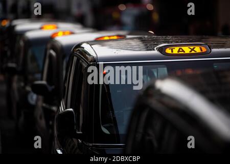 Une file de taxis noirs à l'extérieur de la gare Victoria, Londres. Les chauffeurs de taxi londoniens sont confrontés à de longues attentes pour un aller simple après que l'industrie ait connu une forte baisse de la demande, car les restrictions du coronavirus continuent de réduire les déplacements et le travail au bureau. Banque D'Images