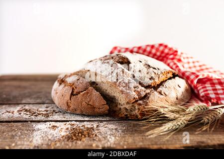 Pain frais coupé en tranches de pain croustillant, décoré sur une table rustique en bois. Gros plan avec une courte profondeur de champ et un espace pour le texte. Arrière-plan pour une boulangerie et t Banque D'Images