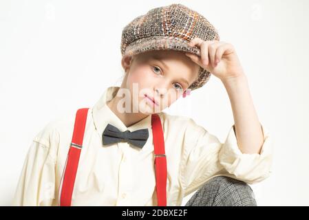 Confiante dans son style. Jeune fille en costume rétro. porte-jarretelles et noeud papillon. Enfant à l'ancienne en béret à carreaux. Style anglais vintage. Pas de jazz Banque D'Images