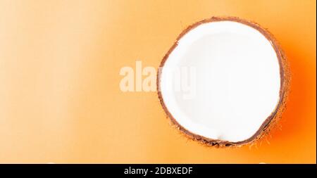 Happy Coconuts Day concept, frais moitié noix de coco, studio tourné isolé sur fond orange Banque D'Images