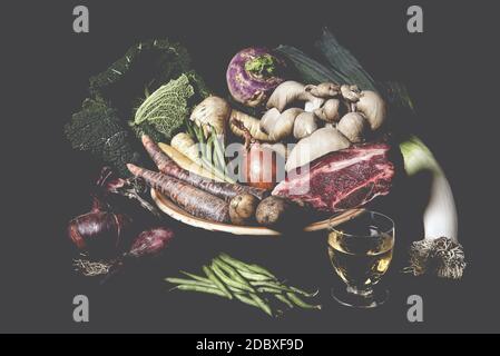 Gros plan de nids de nouilles tagliatelles avec mini tomates roma en forme d'œuf sur une table rustique en bois avec toile de jute, Banque D'Images