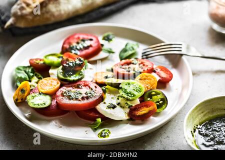 Mozzarella aux tomates cerises, cape de groseille et salade de pesto de basilic Banque D'Images