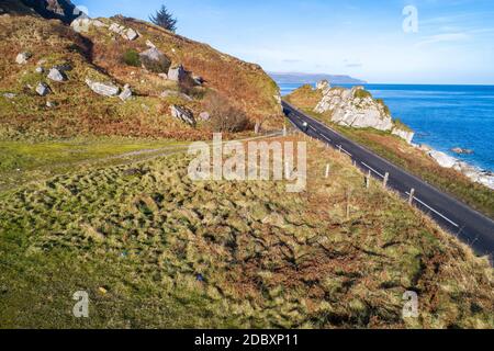 La côte est de l'Irlande du Nord et la route côtière de Causeway avec un cycliste. L'une des routes côtières les plus pittoresques d'Europe. Vue aérienne en hiver Banque D'Images