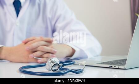 Médecin travaillant sur le bureau. Gros plan du stéthoscope. Un médecin doit se tenir à la main et écouter le patient expliquer sur la station portable avant Banque D'Images