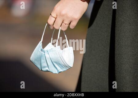 Gros plan masque dans les mains de la femme, femme donnant un masque de protection pendant la pandémie Covid-19 Banque D'Images