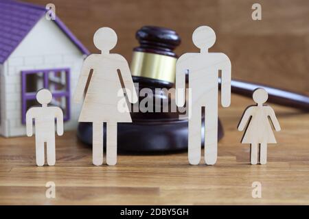 Les figurines en bois des parents et des enfants se trouvent sur la table à proximité maison de jouets et juges marteau Banque D'Images