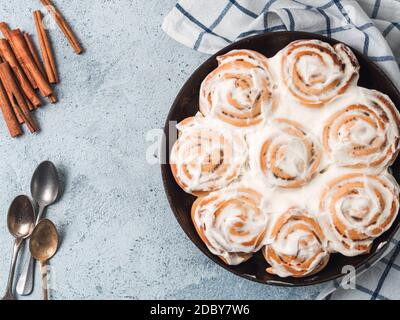 Idée et recette de pâtisseries - parfait petits pains à la cannelle avec garniture, vue de dessus dans une poêle à frire. Petits pains à la cannelle de vegan suédois Kanelbullar avec épice de citrouille, toppin Banque D'Images