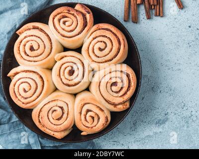 Idée et recette de pâtisseries - rouleaux de cannelle parfaits, vue de dessus dans une poêle à frire. Petits pains à la cannelle végétaliens suédois Kanelbullar à l'épice de citrouille. Pose à plat. Station santé Copy Banque D'Images