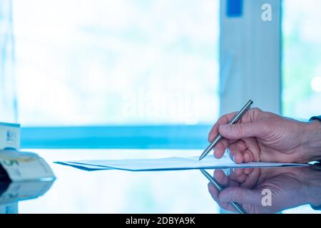 L'homme signe un formulaire de document avec un stylo à bille dans le bureau. Photo de haute qualité Banque D'Images