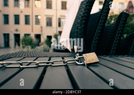 Cadenas et chaîne bloquant une table et des chaises d'un bar fermé ouvert pendant le verrouillage italien en raison du coronavirus. Banque D'Images