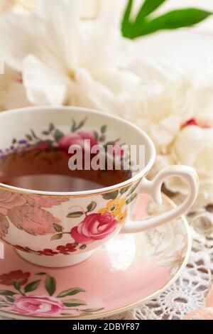 Temps de thé. Une tasse de thé vintage sur une table joliment décorée. Image verticale Banque D'Images