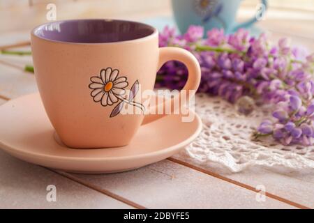 tasse avec café et fleurs de lupin pourpre rose. Lupin à longue tige. Arôme et concept de bonne matinée. Style de vie Banque D'Images