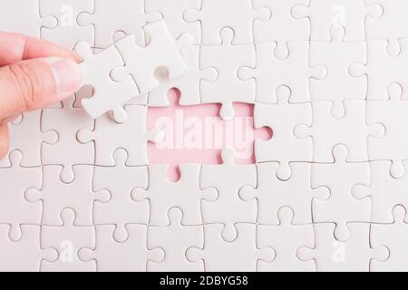Vue de dessus plat de la main tenue dernière pièce papier blanc puzzle jeu dernières pièces mises à place pour résoudre problème mission complète, studio photo o Banque D'Images