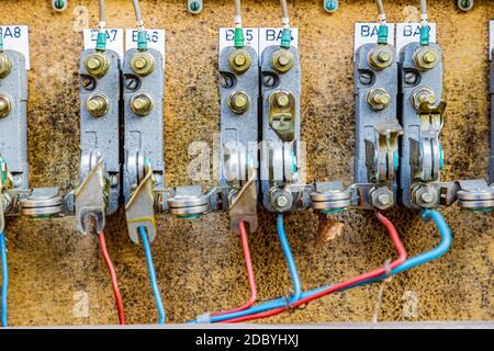 Gros plan d'une ancienne installation électrique dans une boîte à fusibles de relais de commande désutilisée de l'ancien chemin de fer du Rhin (IJzeren Rijn) fils rouges et bleus. Milieu L Banque D'Images