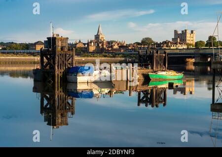 Réflexions de vieux bateaux amarrés le long d'une structure en bois sur la rivière Medway à Rochester, Kent, Royaume-Uni. Banque D'Images