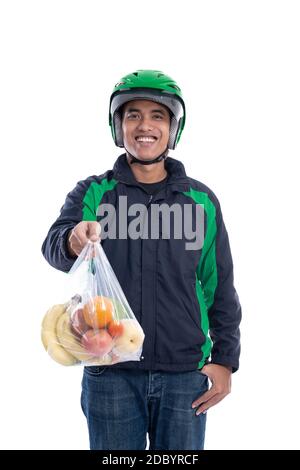 livraison d'épicerie. messagerie portant un casque et une veste uniforme tenant les aliments isolés sur fond blanc Banque D'Images