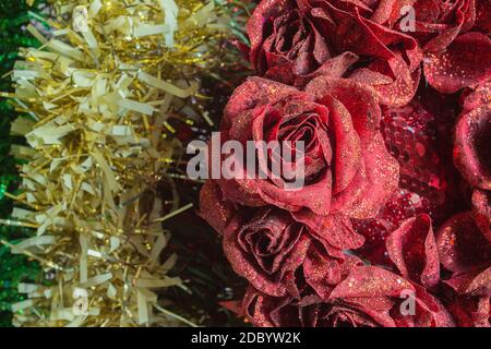 Détail de la couronne de fleur rose en tissu avec paillettes pour la décoration de Noël sur la guirlande colorée. Ornement. Banque D'Images