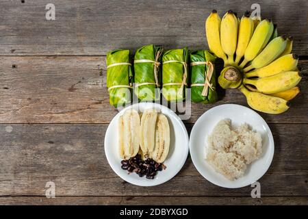 Thaï rempli de lait de coco et de banane, dessert thaïlandais, banane cultivée, lait de coco sur le riz gluant et la banane, vue du dessus Banque D'Images