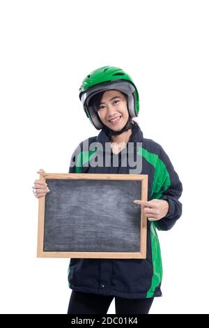 cycliste de taxi femelle portant un casque tenant un tableau noir vierge isolé sur fond blanc Banque D'Images