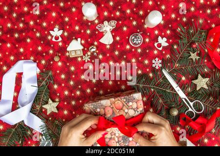 Mains de femme méconnaissable emballage cadeaux de Noël.Xmas fond coloré.vacances d'hiver Décoration saisonnière.création d'un projet DIY.décoration de tricot Banque D'Images