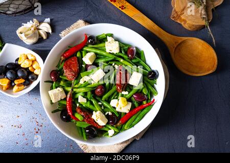 Salade de haricots verts épicée aux olives, fromage feta et tomates séchées Banque D'Images