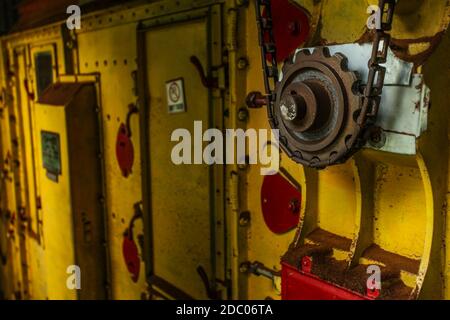 Old rusty d'engrenage et de la chaîne sur un sèche-linge jaune de machines utilisées pour la fabrication de thé usine. Concept de fabrication générale. Banque D'Images