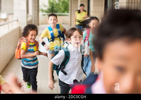 Groupe heureux d'enfants de l'école élémentaire qui s'en vont de l'avant Banque D'Images