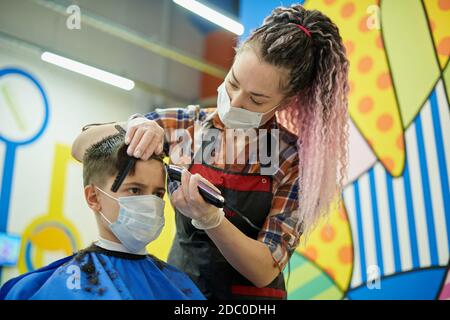 Coiffeuse élégante avec masque de visage, coiffeuse pour enfants salon Banque D'Images