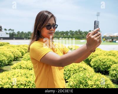 Femmes asiatiques portant des tapis et des lunettes jaunes. Tenez vos selfies dans les attractions avec plaisir. Banque D'Images