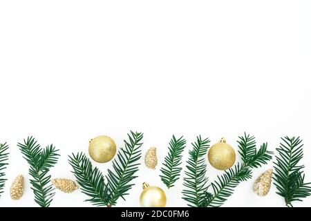 Cadre de Noël avec espace de copie en branches d'arbre à feuilles persistantes et décoration dorée sur fond blanc. Flat lay, vue de dessus Banque D'Images