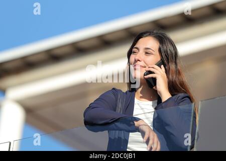 Le locataire de l'appartement appelle au téléphone dans un balcon donnant sur l'extérieur Banque D'Images