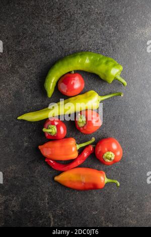 Différents types de légumes poivrons sur table noire. Vue de dessus. Banque D'Images