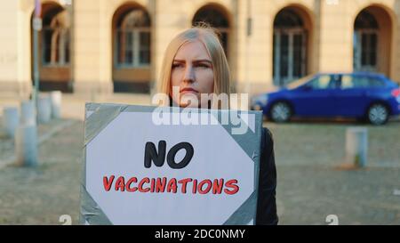 Jeune femme protestant contre la vaccination. Elle marche dans la rue Banque D'Images