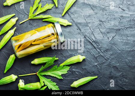 Gousses d'okra en conserve dans un pot en verre. Légumes salés marinés faits maison. Banque D'Images