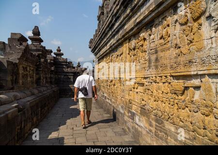 Homme marchant dans l'ancien temple bouddhiste de Borobudur, à Magelang, Java centrale, Indonésie Banque D'Images