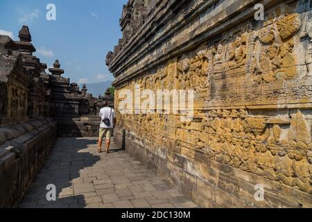 Homme marchant dans l'ancien temple bouddhiste de Borobudur, à Magelang, Java centrale, Indonésie Banque D'Images