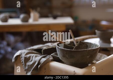 Potter les outils posés sur une table de travail dans une poterie studio Banque D'Images