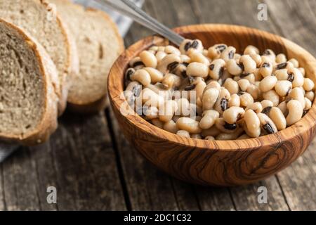 Grains de café à yeux noirs marinés dans un bol en bois. Banque D'Images