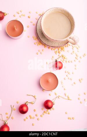 Composition de Noël ou du nouvel an. Décorations, boules rouges, tasse de café, sur fond de papier rose. Vue de dessus, espace de copie, plan de travail. Banque D'Images