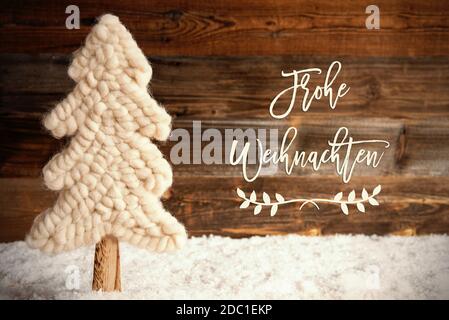 La calligraphie allemande Frohe Weihnachten signifie Joyeux Noël. Arbre de Noël en tissu blanc avec neige. Arrière-plan rustique en bois brun Banque D'Images
