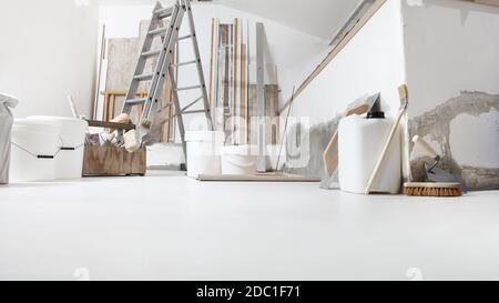 Faible angle de prise de vue en intérieur d'un chantier de construction ou d'un chantier de rénovation avec des outils sur sol blanc avec peinture seaux et primaire jerry can Banque D'Images