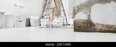 Faible angle de prise de vue en intérieur d'un chantier de construction ou d'un chantier de rénovation à la maison avec des outils avec seaux de peinture sur blanc sol avec espace de copie Banque D'Images