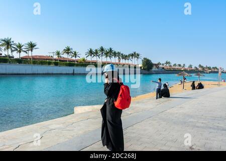 Une touriste féminine avec sac à dos rouge portant hijab à Jeddah Corniche, 30 km station balnéaire de la ville de Jeddah, Arabie Saoudite Banque D'Images