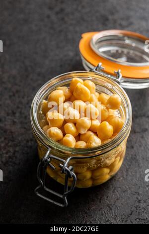 Pois chiches en conserve sains dans un pot sur table noire. Banque D'Images