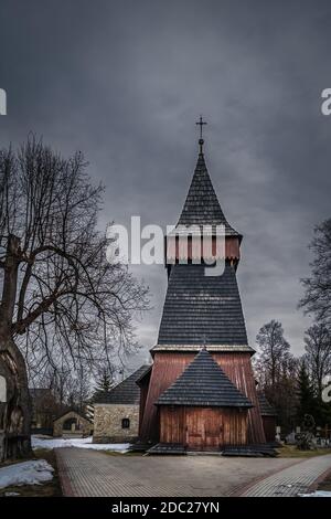 Unique église en bois du XVIIe siècle à Bialka Tatrzanska. Nuages sombres et sombres et ciel spectaculaire. Montagnes Tatra, Pologne Banque D'Images