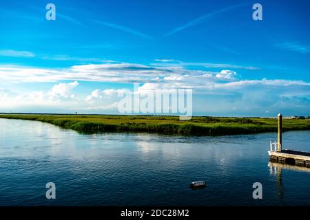 Vue sur la baie luxuriante de Wildwood, New Jersey Avec un petit quai et un bouey flottant dans le Premier plan et un pont en arrière-plan Banque D'Images